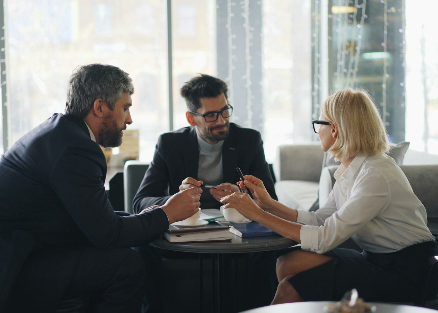Three business owners discussing documents around a table