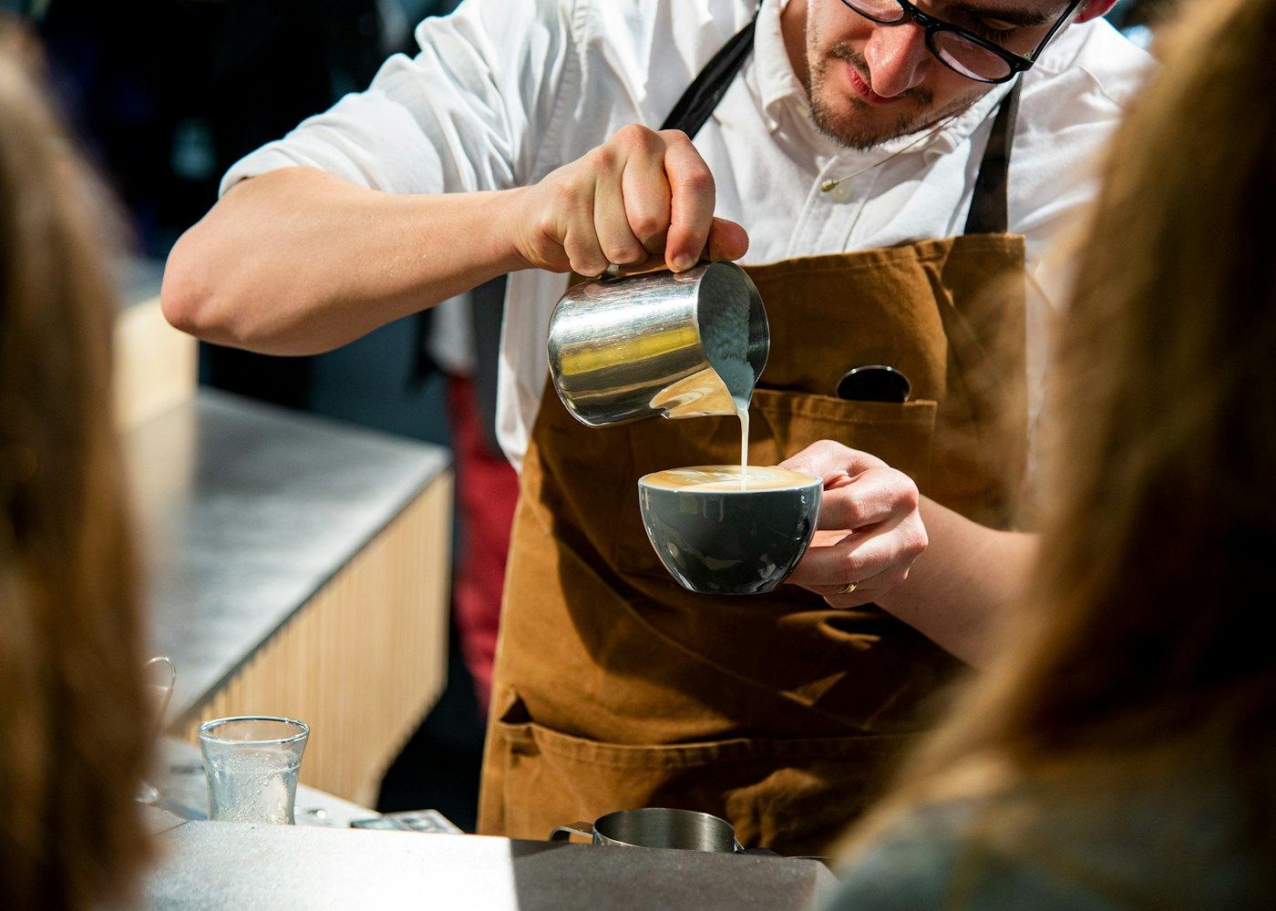 Barista handing a coffee to a customer