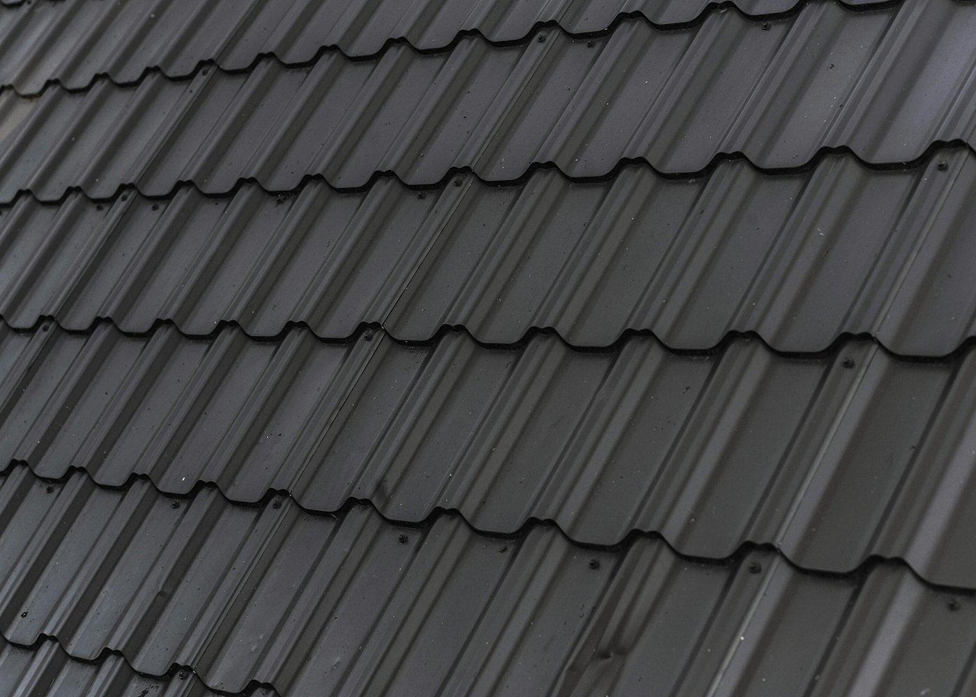 Two roofers fitting slates on a pitched roof